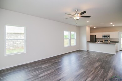Unfurnished living room with dark wood-style flooring, recessed lighting, ceiling fan, baseboards, and a sink