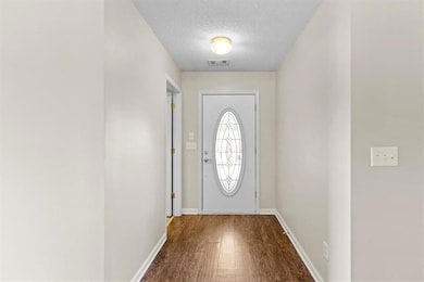 Entryway featuring a textured ceiling and wood finished floors