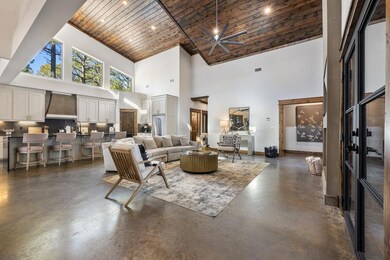 Living room with ceiling fan, a towering ceiling, 