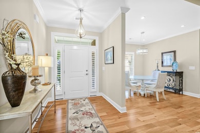 Entryway with a chandelier, crown molding, light wood finished floors, and recessed lighting