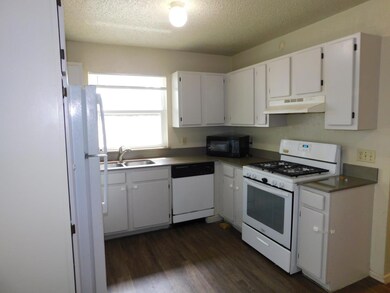 Kitchen featuring a sink, a textured ceiling, dar