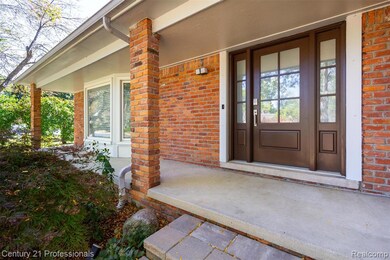 Entrance to property featuring covered porch and brick siding