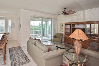 Living room with crown molding, ceiling fan, and light tile patterned floors