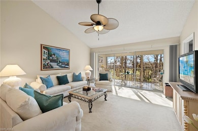 Living room featuring light carpet, a textured cei
