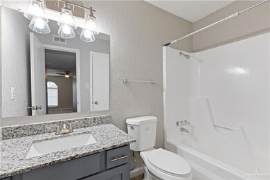 Kitchen featuring under cabinet range hood, visible vents, a sink, white electric range oven, and light wood-style floors