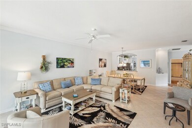 Living room with ornamental molding, ceiling fan,
