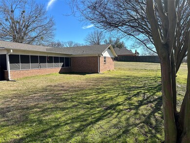 View of side of home with brick siding, a yard, a 