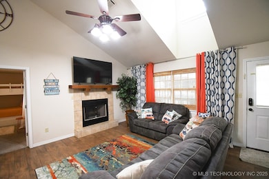 Living room featuring a ceiling fan, high vaulted