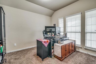 Home office featuring vaulted ceiling and carpet