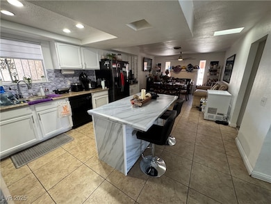 Kitchen featuring black appliances, a sink, a text