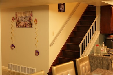 Stairway featuring baseboards and visible vents