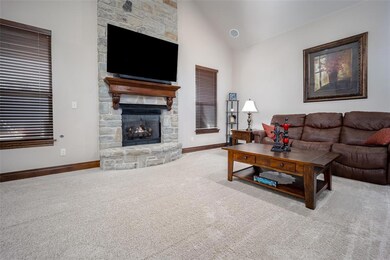 Carpeted living room featuring a fireplace and hig