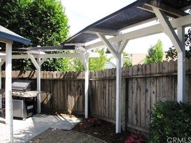 A tall trellis with shade-cloth encloses one side 