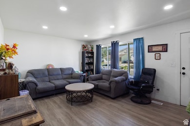 Living room with wood finished floors and recessed lighting