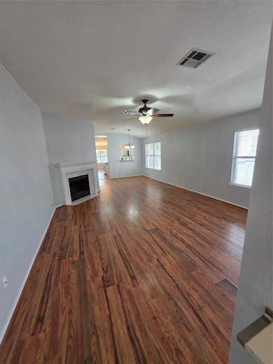 Unfurnished living room featuring dark wood-type 