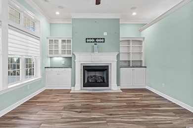 Unfurnished living room with a premium fireplace, ornamental molding, and hardwood / wood-style flooring
