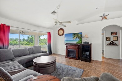 Living room with a ceiling fan, arched walkways, b