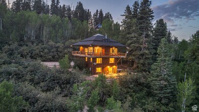 Back of property at dusk with a deck and a forest view