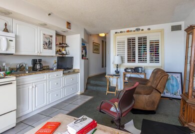 Kitchen with a textured ceiling, white appliances,