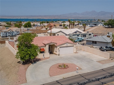 View of front of house with curved driveway, a residential view, a garage, a mountain view, and stucco siding