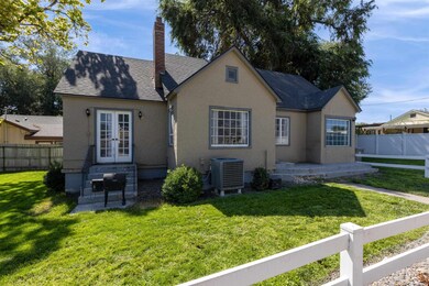 View of front facade with roof with shingles, a chimney, stucco siding, and a patio area