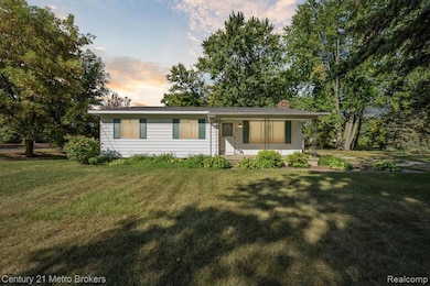 View of front of home featuring a porch, a chimney, and a lawn