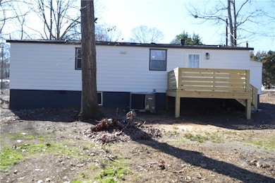 Rear view of property with a deck and central AC u