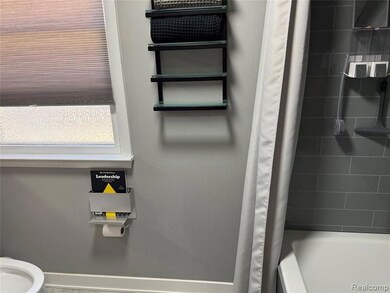 Full bathroom with shower / tub combo and baseboards