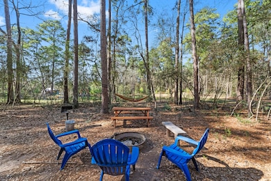 The photo shows a serene, wooded backyard with tal