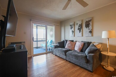 Living room featuring crown molding, ceiling fan, 