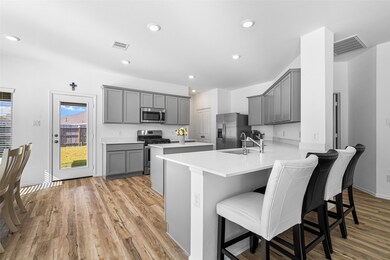 Another view of the kitchen showcases the peninsula island, offering additional seating and counter space while enhancing the open and inviting layout of the home.