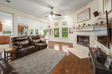Living room with ceiling fan, light wood-type flo