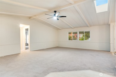 Another angle shows the skylight bringing in natural light, complemented by a new ceiling fan for comfort. Plush new carpet—including 8lb padding and a vapor barrier—adds a soft touch underfoot.