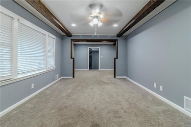 Basement with ceiling fan and light colored carpet