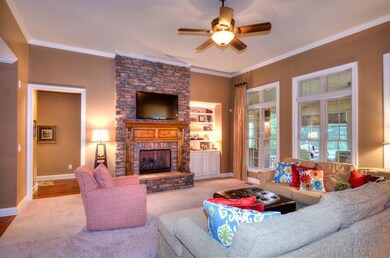 GRACIOUS GREAT ROOM WITH STONE FIREPLACE , BUILT INS AND WALL OF WINDOWS