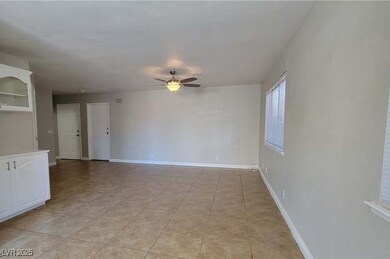 Spare room featuring a ceiling fan and baseboards