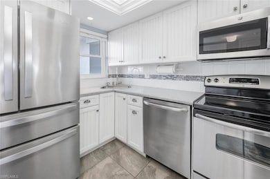 Kitchen with a sink, light countertops, white cabi