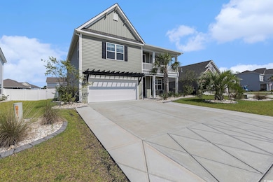 View of front of property with board and batten siding, concrete driveway, a garage, a balcony, and a residential view