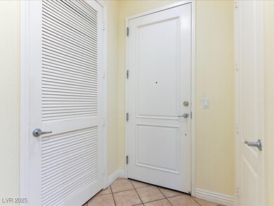 Doorway with baseboards and light tile patterned f