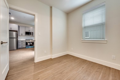 Unfurnished room with light wood-type flooring and baseboards