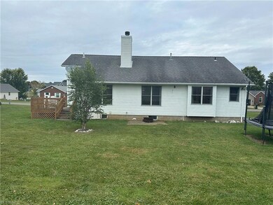 Rear view of house with a wooden deck, a trampolin