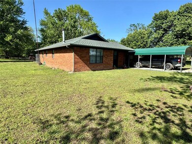 View of side of property with a carport, a yard, a