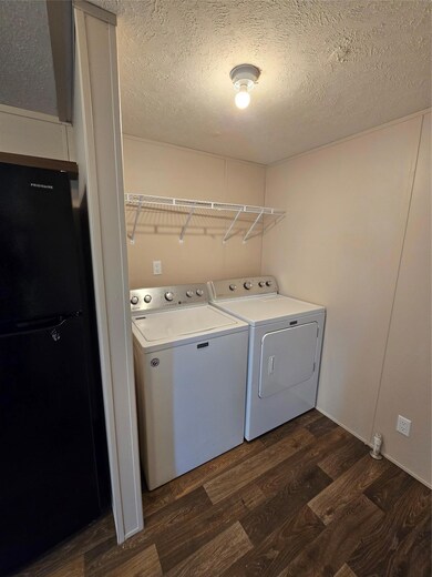 Laundry room featuring a textured ceiling, laundr