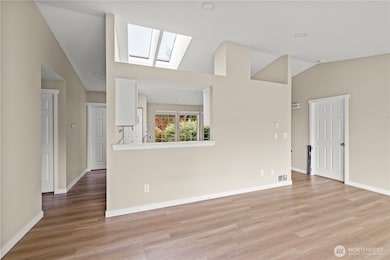 Bright and airy with dual skylights filling the main living area with natural light. Modern neutral paint palette complements new flooring for a move-in-ready feel.