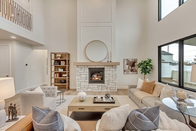 Living area with a towering ceiling, wood finished floors, and a fireplace
