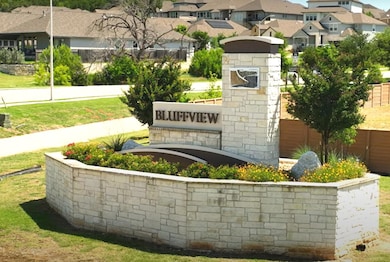 Community / neighborhood sign featuring a residential view and a yard