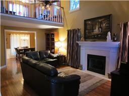 LIVING AREA WITH FIREPLACE OVERLOOKED BY LOFT AREA, HARDWOOD FLOORS!