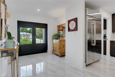 Entryway with french doors, recessed lighting, light marble finish floors, and baseboards