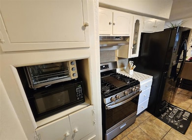 Kitchen with white cabinets, under cabinet range h