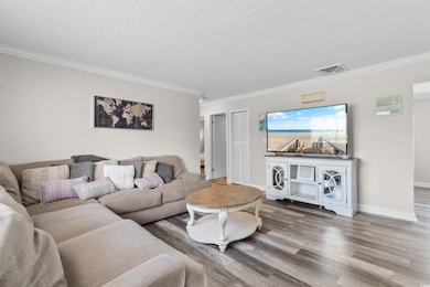 Living area with ornamental molding, wood finished